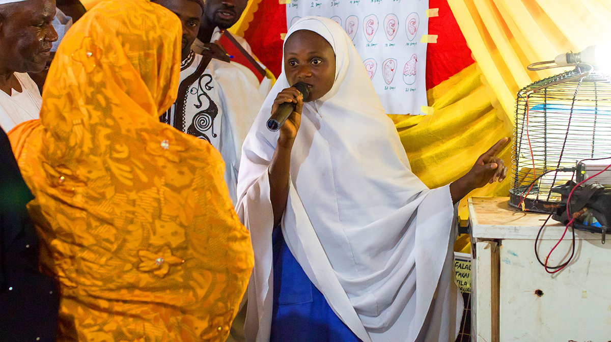 A girlsâ association member in a DLA school community in Nigeria explains the science behind a solar powered egg incubator created by her group for a local exhibition (Photo: Discovery Learning Alliance).