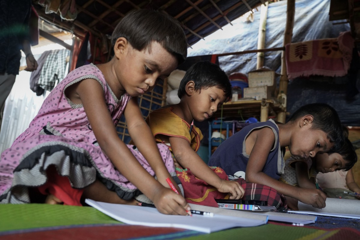 Rohingya children try to draw pictures with the note books and color pencils donated by VSO at the home-based child friendly center at Jamtoli. Photo: VSO/ Abir Abdullah