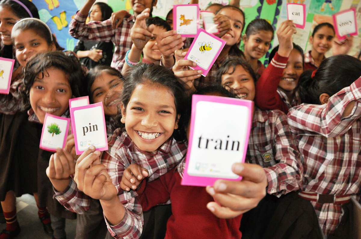 Girls excitedly sharing their SMS Story learning cards in a school in Delhi. Photo: VSO